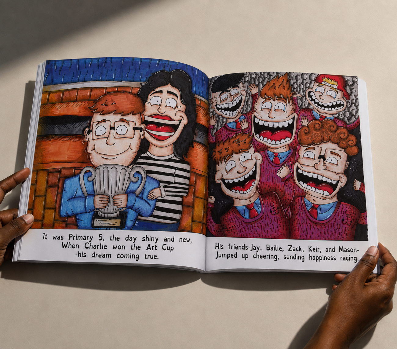 An open spread of Charlie holding the Primary 5 Art Cup while a crowd of grinning friends cheers behind him.